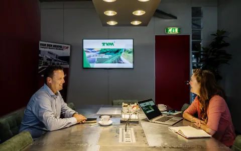 Das Expertenteam von TVM sitzt gemeinsam an einem Meeting-Tisch.