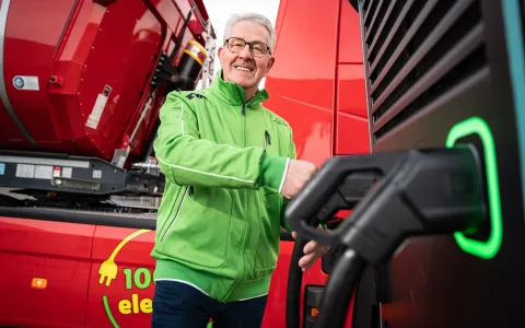LKW fährt auf Straße zwischen Feldern