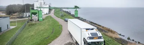 LKW auf Straße zu Fabrikgelände